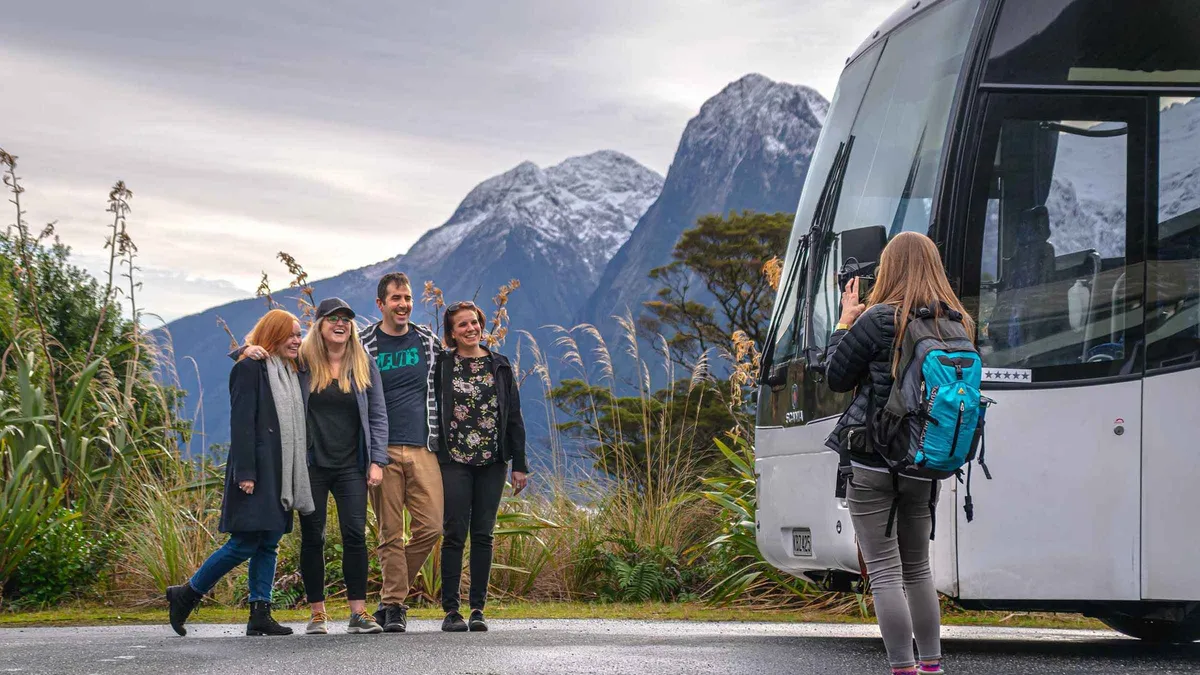 Coach and cruise day trip passengers on the deck near Stirling Falls on a Milford Sound boat tour from Queenstown