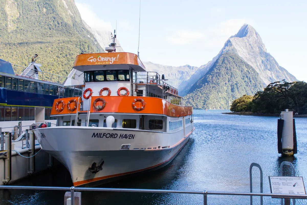 A Milford Haven cruise boat at the wharf with Mitre Peak behind on a Milford Sound cruise.
