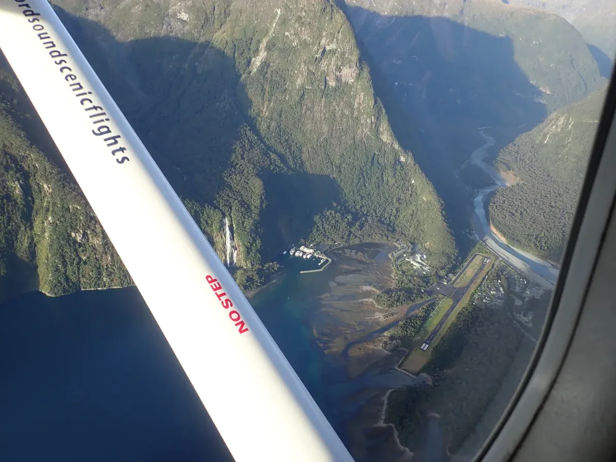 Aerial view of the head of Milford Sound with the airstrip and the fiord running away.