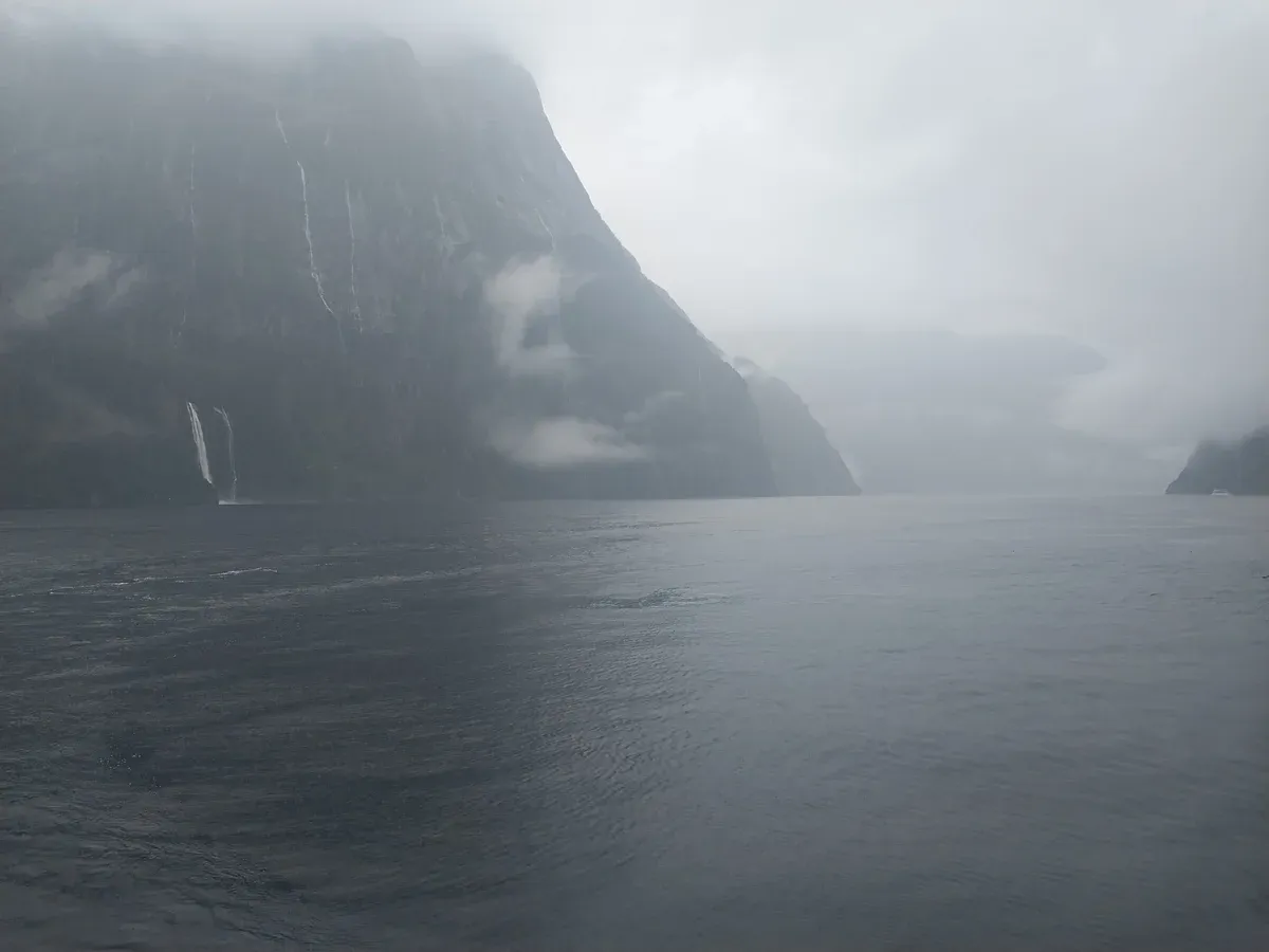 Cloud and mist over the water of Milford Sound on a wet day.